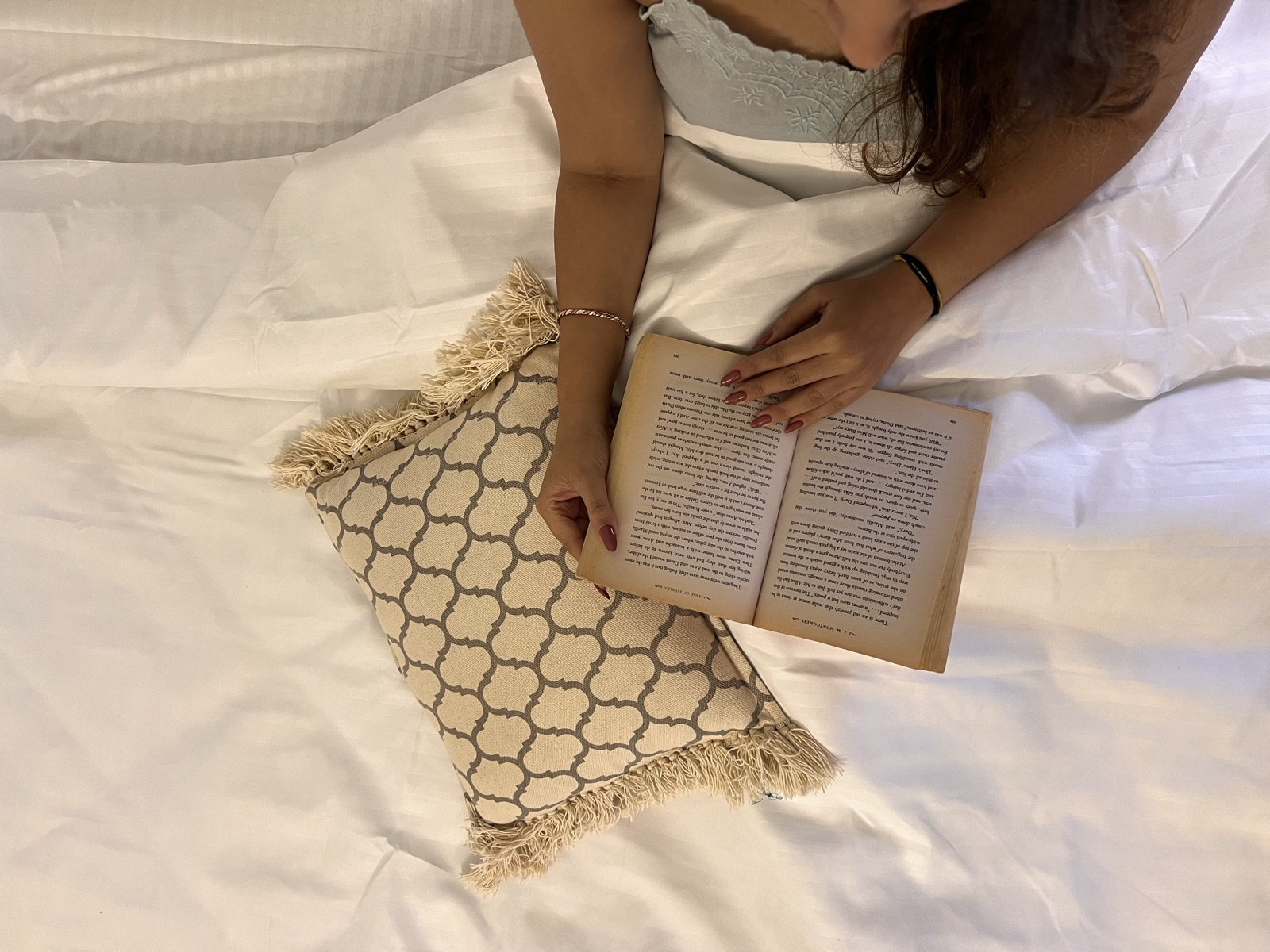 A guest reading in bed on crisp white hospitality linen